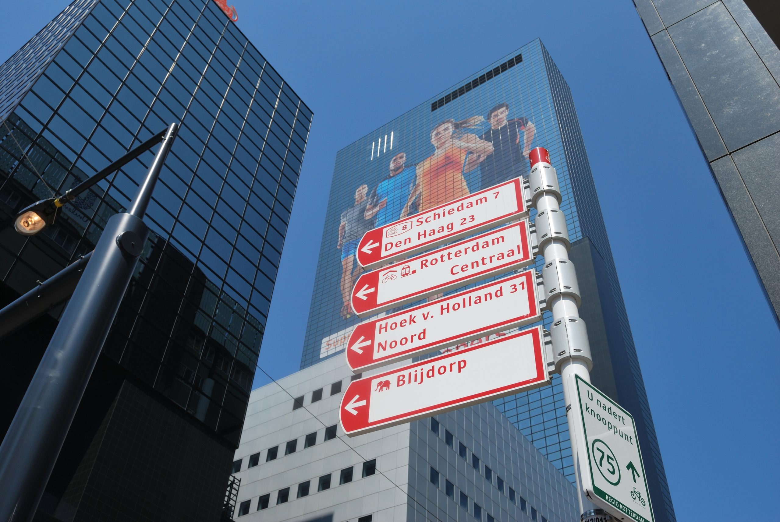 Hardlopers met mega sticker op NN gebouw in Rotterdam tijdens de marathon