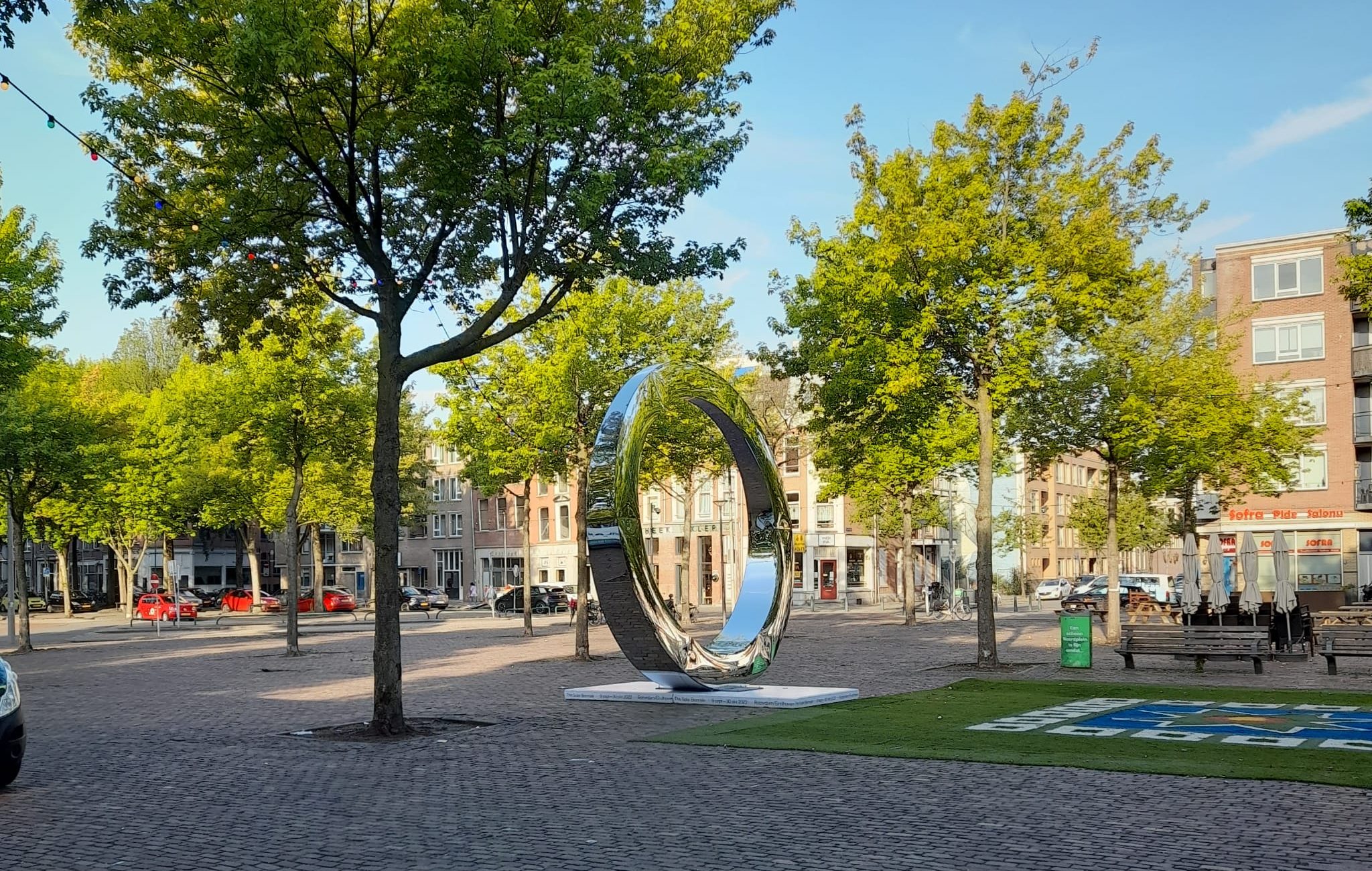 Grote spiegelende cirkel op het Noordplein in Rotterdam als communicatie in de buitenruimte